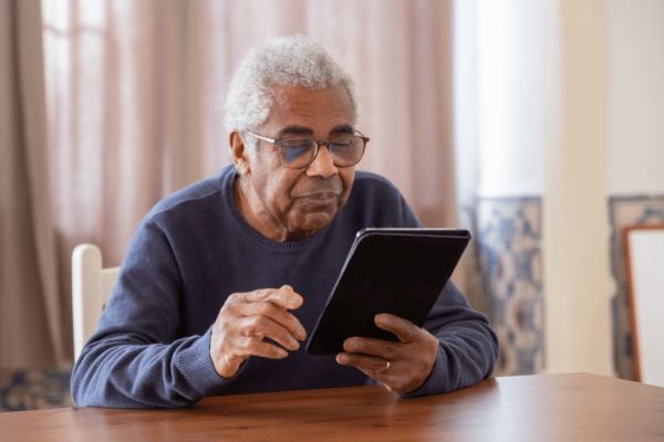 Photo of a man looking at a website on his tablet