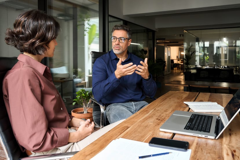 Photo of two coworkers discussing goals and challenges